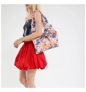 Floral print cotton tote bag with a large bow detail shown on a fashion model