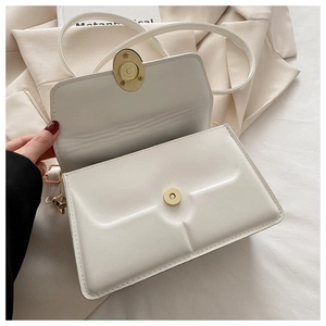 Detail of white PU leather crossbody bag with golden magnetic buckle and interior space