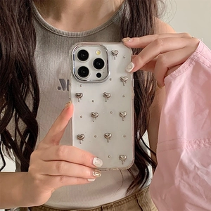 Coque iPhone blanche avec cœurs argentés 3D effet liquide montrée lors d'un selfie