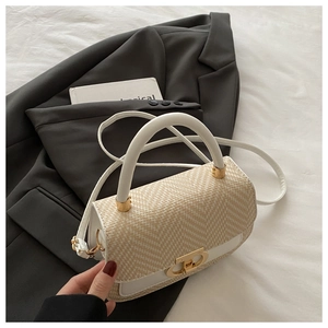 Détail de la texture en paille tressée et du cuir blanc sur un sac à main de luxe chic