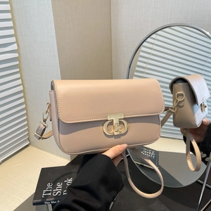 Beige PU leather crossbody bag with a gold T-lock shown in a reflective mirror setting