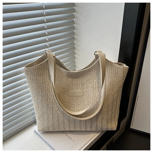 Detail of V-shaped woven straw texture and leather fashion tag on vintage tote bag