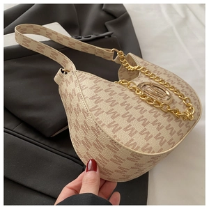 Detail of beige half-moon bag with letter M print, gold chain, and metal logo emblem