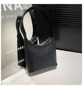 Close-up of black woven hobo bag featuring intricate leather texture and silver zipper