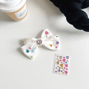 Detail of white satin bow phone grip with colorful rhinestones and DIY sticker set