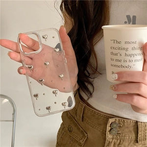 Coque iPhone transparente avec cœur 3D argenté et paillettes tenue à la main