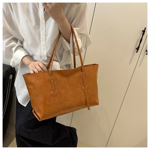 Close-up of a vintage brown leather tote bag with elegant stitching for daily commute