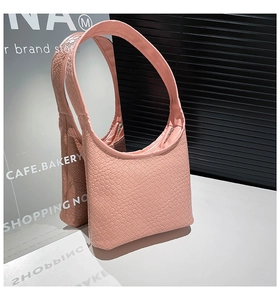 Macro detail of pink woven texture on a minimalist shoulder bag with mirror reflection