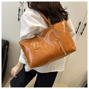 Close-up of caramel brown oversized tote bag with glossy finish and durable shoulder straps