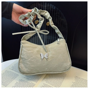 Detail of mint green ruched shoulder bag with butterfly buckle and bow on strap