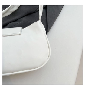 Close-up of the smooth white leather finish and top closure on the pleated shoulder bag