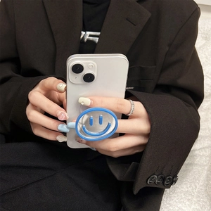Detail of silver mirror phone grip with blue smiley face mounted on a white smartphone