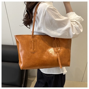 Detail of the camel retro tote bag showing textured faux leather and stitching