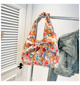 Detail of floral print tote bag with large decorative bow and wide shoulder handle