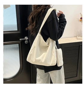 Detail of cream corduroy tote bag with mini pouch accessory shown on a model
