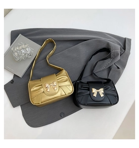 Top view of pleated shoulder bags in gold and black with metallic bow clasps and PU leather