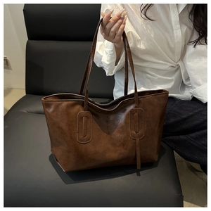 Detail shot of the vintage brown faux leather texture and strap of this large tote bag