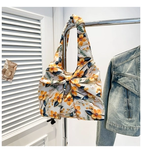Detail of white floral tote bag featuring a large decorative bow and orange flower print