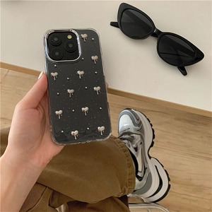 Détail de la coque iPhone avec cœurs argentés 3D et paillettes sur fond noir