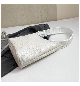 Detailed close-up of white woven texture and checkerboard craftsmanship on a shoulder bag