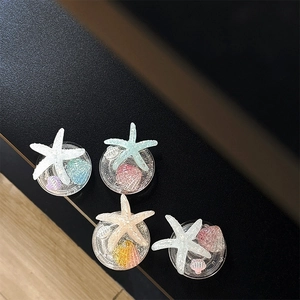 Ocean glitter resin phone grips with starfish and seashell patterns on black background