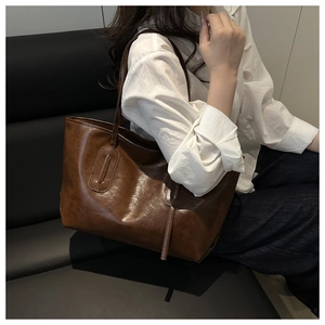 Detailed view of vintage brown PU leather tote bag worn by model for daily commute