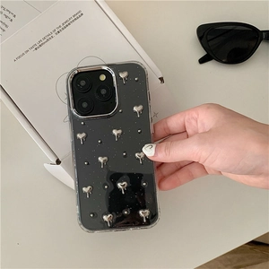 Détail de coque iPhone avec motifs de cœurs en métal liquide et fini pailleté