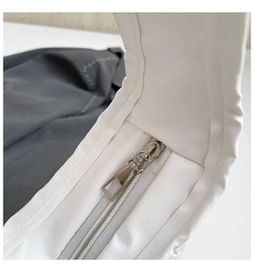 Detail of white PU leather bag showing seamless stitching and silver metal zipper slide