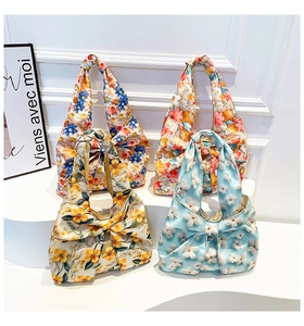 Detail of floral tote bags with large bow design on elegant white display steps