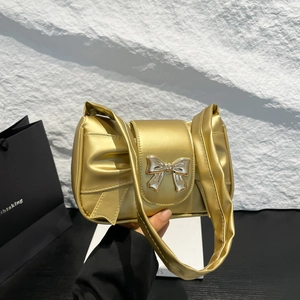 Chic metallic gold underarm bag with a decorative bow clasp and ruched top handle