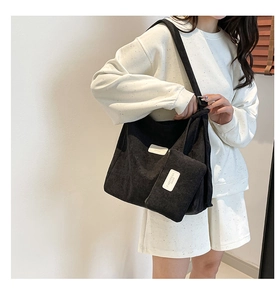 Close-up of black corduroy tote bag texture and brand tag with matching small coin purse