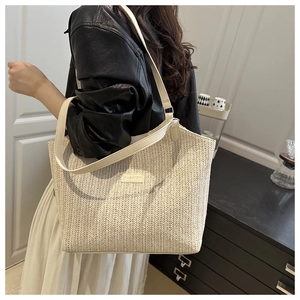 Detail of the woven texture and fashion logo on this stylish white straw tote bag