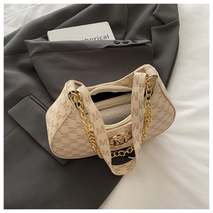 Macro shot of cream underarm bag featuring letter M print and gold metal logo buckle