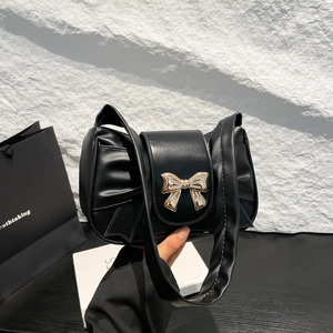 French style black baguette underarm bag with golden bow and pleated leather detail