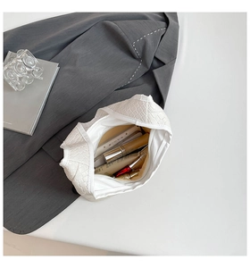 Internal view of white woven handbag showing large capacity and smooth zipper closure