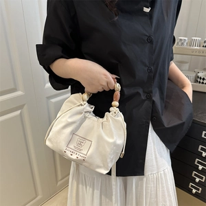 Chic cream beaded drawstring handbag with marble effect handle and teddy bear print