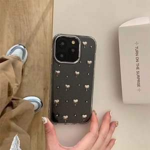 Gros plan d'une coque iPhone noire avec des cœurs de lave 3D argentés en main