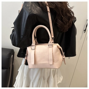 Détail du sac Boston rose clair avec ferrures argentées porté par un modèle