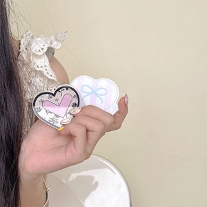 Détail d'un support de téléphone en forme de cœur avec motifs floraux et nœuds