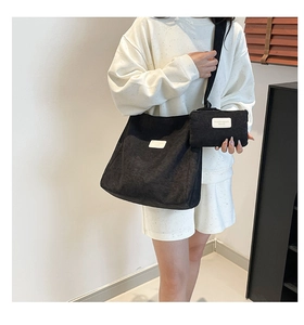 Detail of black corduroy tote bag set showing fabric texture and shoulder strap on model