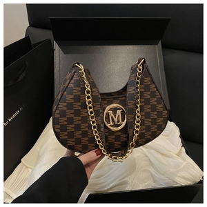 Close-up of retro printed shoulder bag with gold M-buckle in elegant gift box