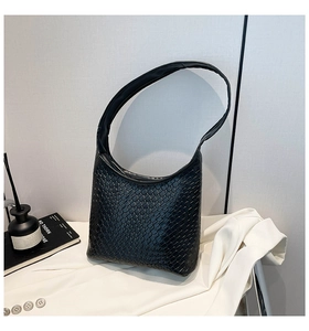 Detailed view of the black woven leather texture on a stylish large hobo bucket shoulder bag