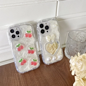 Detail of pearl finish iPhone case with 3D red cherries and white rose bow accents