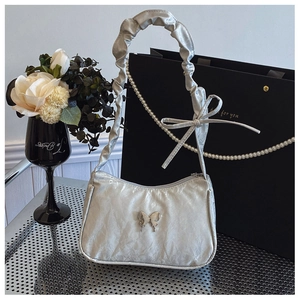 Silver metallic pleated shoulder bag featuring butterfly ornament and pearl chain detail