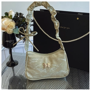 Detail of light olive pleated shoulder bag with gold butterfly buckle and ribbon strap