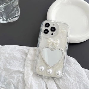 Detail of DIY decoden iPhone case with heart mirror, cream texture and pearls