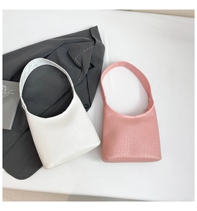 Close-up of white and pink hobo bags with crocodile texture and minimalist strap design