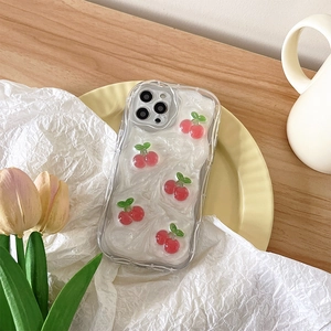 Close-up of iPhone case with white cream texture and 3D red cherry decorations