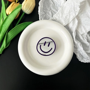 Macro view of a round silver mirror phone socket with a purple smiley face design