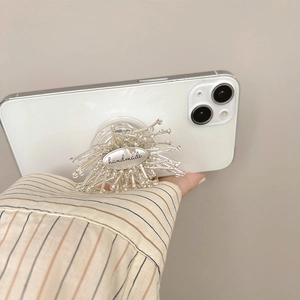 Detailaufnahme der handgefertigten Perlen-Blumen-Handyhalterung mit Metallplakette